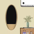 Oval Metal Frame Mirror On Light Wall Near Wooden Table With Green Plant Vase
