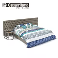 Tufted Headboard Bed With Blue And White Patterned Bedding And Small Round Side Table