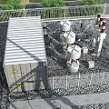 Industrial Plant Facility With Substation Transformers Landscaped Greenery And Surrounding Trees