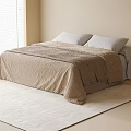 Double bed with beige striped blanket and white pillows on soft beige rug near window