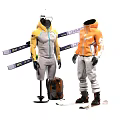 Two Models Wearing Light Yellow And Orange Ski Suits With Skis And Backpack