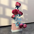 Stylish Floral Arrangement with Red Roses Blue Stems Leaves in Pink White Vase Light Wall