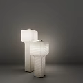 Two White Floor Lamps With Square Striped Shades And Cylindrical Stands In Dark Background