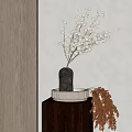 White Flowers in Textured Black Vase on Small Wooden Table with Decorative Brown Branches