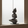 Modern Abstract Sculpture With Stacked Irregular Stones By Window Blinds