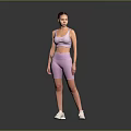 A woman wearing pink sports bra and shorts with white sneakers against gray background