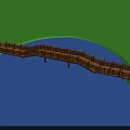 Red Arch Bridge Spanning Blue River With White Railings And Green Grass