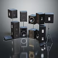 Various Black Audio Speakers In Different Sizes And Shapes On Stands And Floor