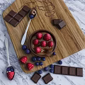Fresh Raspberries And Blueberries With Chocolate Pieces On Wooden Cutting Board