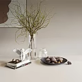 Floral Display In Transparent Vase With Twigs Buds Angel Figurine On Books Pinecones Black Plate