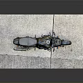 Black and Yellow Striped Motorcycle Parked on Gray Mat with Dark Background