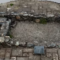 Old Stone Wall Enclosed Space Featuring Gravel Ground Brick Paving and Small Grass