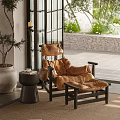 Brown Leather Lounge Chair With Ottoman Side Table Potted Plant Indoor Outdoor Stone Wall Greenery