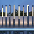 Modern Tall Vertical Outdoor Lights Illuminated In Garden With Trees And Water