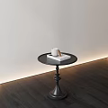 Black Round Side Table With White Cup And Book On Dark Wooden Floor