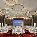 Elegant Banquet Hall With Hanging Chandeliers Large Screen And White Tablecloth Tables On Red Carpet