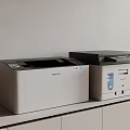 Samsung Laser Printer And Multifunction Printer On White Cabinet With Gray Wall