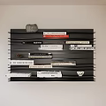 Stylish Black Layered Wall Shelf Displaying Books Magazines and Decorative Stone