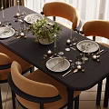 Modern Black Dining Table Set with Orange Chairs Dinnerware Candles and Green Floral Arrangement