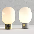 Table Lamps with White Oval Shades Gold Gray Bases on White Brick Wall White Tabletop