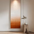 Long Vertical Decorative Painting With Orange Brown Gradient And Wooden Side Table With White Vase