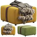 Stylish Yellow and Green Ottoman with Gray Pom Pom Blanket and Brown Strap Detail