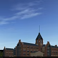 Red Brick School Building With Blue Roof Tower Surrounding Trees And Parking Cars