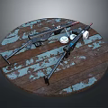 Two Black Long Guns on a Wooden Round Platform with Blue and White Peeling Paint