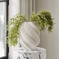 Green Foliage in White Spiral Patterned Vase on Black and White Patterned Table
