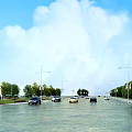 Urban Road Infrastructure Featuring Street Lights Vehicles And Green Trees Alongside Lanes
