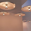 Three Modern Wall Lamps On Wall With Round Shades And Visible Light Bulbs