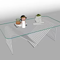 Modern Glass Top Coffee Table With Metal Frame And Small Decor Items And Potted Plant