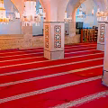 Cartoon Mosque Interior Scene With Red Striped Carpets White Patterned Pillars And Hanging Chandeliers