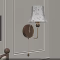 Wall Lamp With White Floral Lampshade And Wooden Base On Light Wall Near Picture Frame
