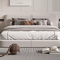 Modern White Upholstered Double Bed With Multiple Pillows Striped Rug And Open Book