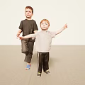 Two Young Boys Standing With Arms Outstretched Against Light Colored Background And Carpeted Floor