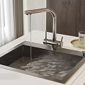 Stainless Steel Kitchen Sink with Water Flowing from Faucet on White Countertop