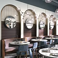 Modern Restaurant Interior With Circular Mirrors Pendant Lights Booth Seating And Round Dining Tables