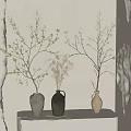 Gray Black and Beige Ceramic Vases with Blossom Branches on White Pedestal Against Neutral Wall