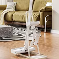 White Vacuum Cleaner In Living Room With Wooden Floor Green Sofa And Patterned Rug