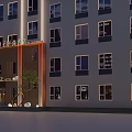 Modern Multi Story Orange Hotel Building With Illuminated Exterior In City Night