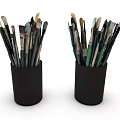 Various Paintbrushes Stored in Two Black Pen Holders on White Background