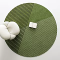 Green Striped Round Rug With White Cushion And Open Book