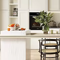 Modern Restaurant Kitchen Interior With White Cabinets Island Counter Chairs Plant And Natural Light
