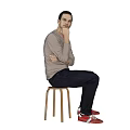 Man Sitting On Stool Thinking With Hand On Chin In Light Pink Long Sleeve Shirt