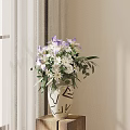 White Vase with Purple Irises White Flowers and Green Leaves on Wooden Table Near Curtain