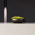 Bonsai Plant with Green Moss in Black Pot on White Tabletop with Lighting