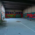 Abandoned Building Interior with Colorful Graffiti Art on Walls Empty Space and Exposed Ceiling Beams