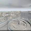 Large Circular Concrete Structures Amid Collapsed Building Ruins With Distant Multi Story Building