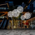 Multiple Illuminated Spherical Perforated Art Installations In Urban Outdoor Plaza With Modern Architecture